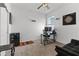 Bedroom with ceiling fan, closet, large window, desk with computer, and comfortable dark sofa at 9392 Revere Ave, Leesburg, FL 34788