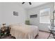 Bright bedroom featuring a cozy bed, green rocking chair, side table, and natural lighting at 9392 Revere Ave, Leesburg, FL 34788