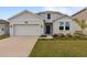 Charming single-story home with a well-manicured lawn, inviting curb appeal, and a two car garage at 9392 Revere Ave, Leesburg, FL 34788