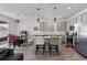 Modern eat-in kitchen featuring stainless steel appliances, an island with bar seating, and grey cabinetry at 9392 Revere Ave, Leesburg, FL 34788