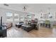 A spacious open-concept living room and kitchen features wood-look tile flooring, offering a modern design at 9392 Revere Ave, Leesburg, FL 34788