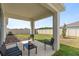 Covered patio with outdoor seating overlooking the fenced backyard at 9392 Revere Ave, Leesburg, FL 34788
