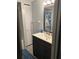 Bathroom featuring a dark vanity, mirror, and shower with sliding glass door at 130 Oak Tree Dr, Debary, FL 32713