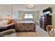 Cozy bedroom with a floral comforter, wooden furniture, and a bright window for natural light at 100 Silver Beach Ave # 716, Daytona Beach, FL 32118