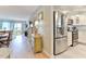 Hallway leading to a kitchen, living room, and balcony with stainless steel refrigerator at 100 Silver Beach Ave # 716, Daytona Beach, FL 32118