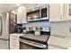Well-equipped kitchen with stainless steel microwave, oven, refrigerator, and white cabinets at 100 Silver Beach Ave # 716, Daytona Beach, FL 32118