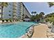 Inviting community pool with lounge chairs and tropical landscaping, perfect for relaxation at 100 Silver Beach Ave # 716, Daytona Beach, FL 32118