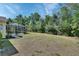 Expansive lawn area is perfect for outdoor activities, bordered by tropical plants and the screened pool area at 1033 Pearl Tree Rd, Deltona, FL 32725