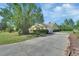 Spacious driveway and side view of a well-maintained, single-story home with mature trees at 1033 Pearl Tree Rd, Deltona, FL 32725