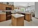 The kitchen offers an island, dark appliances, wood cabinets, and laminate floors at 1033 Pearl Tree Rd, Deltona, FL 32725