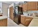 View of the kitchen featuring wooden cabinets, laminate floors, and a black refrigerator at 1033 Pearl Tree Rd, Deltona, FL 32725