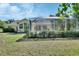 Relaxing pool area within screened enclosure, surrounded by mature landscaping and lush green lawn at 1033 Pearl Tree Rd, Deltona, FL 32725