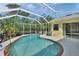 Screened-in pool with brick accents, surrounded by lush tropical greenery at 1033 Pearl Tree Rd, Deltona, FL 32725