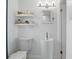 Clean bathroom with a pedestal sink, modern lighting, and open shelving at 104 Hester Ave, New Smyrna Beach, FL 32168