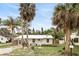 Lovely home with palm trees, metal roof, a small table with chairs, and beautiful landscaping at 104 Hester Ave, New Smyrna Beach, FL 32168