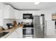 Kitchen featuring stainless steel appliances, white cabinets, and stone countertops at 104 Hester Ave, New Smyrna Beach, FL 32168