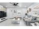 Bright living room features tiled floors, a ceiling fan, and access to the front door at 104 Hester Ave, New Smyrna Beach, FL 32168