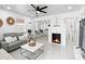 Bright, modern living room with fireplace, gray couch, and seamless flow to kitchen at 104 Hester Ave, New Smyrna Beach, FL 32168