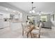 Open dining area with modern lighting flowing into a well-lit kitchen and living room at 1044 Deltona Blvd, Deltona, FL 32725