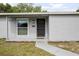 Close-up view of the front door and porch with manicured garden beds at 1044 Deltona Blvd, Deltona, FL 32725