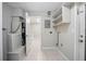 Functional utility room featuring appliances, storage shelves, and access to other areas of the home at 1044 Deltona Blvd, Deltona, FL 32725