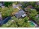 Overhead view of a private backyard oasis with a sparkling pool, bordered by mature trees and lush landscaping at 105 Laguna Ct, Sanford, FL 32773