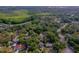 Wide aerial view of a residential area with dense trees, showcasing streets, homes, and surrounding lush greenery at 105 Laguna Ct, Sanford, FL 32773