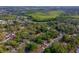 High aerial view of a residential area with arrow pointing to a home, showcasing streets, homes, and surrounding lush greenery at 105 Laguna Ct, Sanford, FL 32773