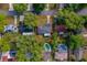 Aerial view of a neighborhood with tree-lined streets, a home is outlined in red, showing the layout, pool, and green spaces at 105 Laguna Ct, Sanford, FL 32773