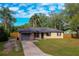 Charming home featuring a well-manicured lawn, mature trees, and a paved driveway at 105 Laguna Ct, Sanford, FL 32773