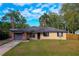 Inviting home with a lush green lawn, mature trees, and a paved driveway, creating curb appeal at 105 Laguna Ct, Sanford, FL 32773