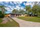 Inviting single-story house featuring a well-manicured lawn, a paved driveway, and a single-car garage at 105 Laguna Ct, Sanford, FL 32773