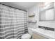 A bathroom features floating shelves, a gray shower curtain and neutral wall color at 110 Cypress Woods Ct # 2B, Deltona, FL 32725
