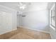 This carpeted bedroom features a ceiling fan, closet, and bright natural light at 110 Cypress Woods Ct # 2B, Deltona, FL 32725