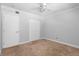 A clean, carpeted bedroom featuring a ceiling fan, closet, and white trim at 110 Cypress Woods Ct # 2B, Deltona, FL 32725