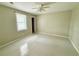 An inviting bedroom featuring neutral walls, tile floors, a ceiling fan, and a door to the hall at 111 S Delaware Ave, Deland, FL 32720