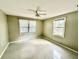 A bright bedroom with neutral walls, tile floors, ceiling fan, and two windows with blinds for ample natural light at 111 S Delaware Ave, Deland, FL 32720