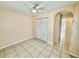 A comfortable bedroom with tile floors, closet, and an arched entrance to the hallway at 111 S Delaware Ave, Deland, FL 32720