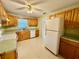 Well-lit kitchen featuring wooden cabinets, a double sink, modern appliances, and access to other rooms at 111 S Delaware Ave, Deland, FL 32720