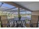 Relaxing balcony featuring chairs and a table with a view of the calm lake and neighboring houses at 1117 Oxbridge Ln, Ormond Beach, FL 32174