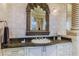 Bathroom vanity showcases a granite countertop and ornate mirror at 1117 Oxbridge Ln, Ormond Beach, FL 32174