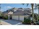 Stunning exterior view showcasing tile roof, three-car garage, beautiful landscaping and driveway at 1117 Oxbridge Ln, Ormond Beach, FL 32174