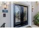 Close-up of the elegant front doors with decorative glass, sconces, and exterior house number at 1117 Oxbridge Ln, Ormond Beach, FL 32174