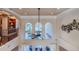 Open living room with high ceilings, large windows overlooking the pool, and a modern ceiling fan at 1117 Oxbridge Ln, Ormond Beach, FL 32174