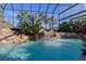 Beautiful enclosed pool area with rock waterfall and lush tropical landscaping, creating a resort-like experience at 1117 Oxbridge Ln, Ormond Beach, FL 32174