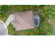 Aerial view showcasing a private backyard pool and patio area, surrounded by lush landscaping at 115 San Marino Ln, Deland, FL 32724