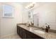 Well-lit bathroom featuring a double vanity with granite countertop and large mirror at 115 San Marino Ln, Deland, FL 32724