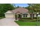 Charming single-Gathering home with brick driveway, well-kept landscaping, and a welcoming stone facade entrance at 115 San Marino Ln, Deland, FL 32724