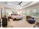 A primary bedroom shows a king bed, ensuite bathroom, ceiling fan, and hardwood flooring at 115 San Marino Ln, Deland, FL 32724