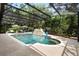 Spacious screened-in pool boasts ample seating and a beautiful stone fountain feature at 115 San Marino Ln, Deland, FL 32724